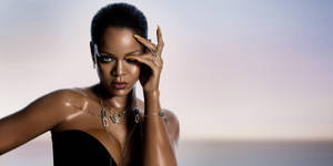Rihanna 在工作室肖像中佩戴珠寶和紋身，背景是日落。