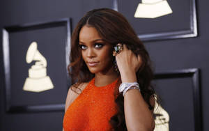 Rihanna 在格林美獎活動中身穿閃亮橙色連衣裙。