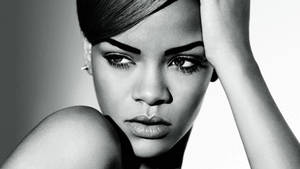 Rihanna 的黑白工作室肖像，手放在頭上。