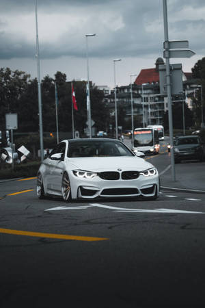 多雲天空下潮濕城市街道上的白色BMW M4雙門轎跑車