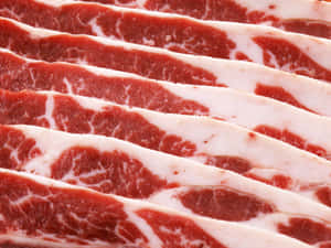 一排排薄切大理石紋生牛肉，紅肉與白脂肪相間。 — 4:3 壁紙