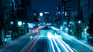 夜晚的城市街道，移動車輛留下發光的光跡。