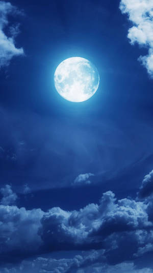 滿月在深藍色夜空中穿過雲層閃耀