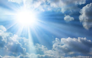 太陽穿過白雲在藍天中明亮地照耀。