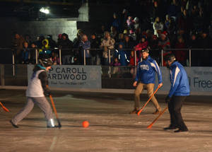 夜間比賽中，冰上 broomball 球員在溜冰場上，人群觀看。 — 夜晚 GIF 壁紙