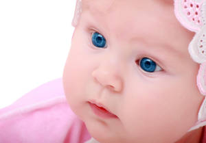 戴著粉紅色蕾絲頭帶、擁有明亮藍眼睛的嬰兒。