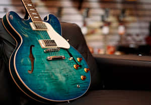 一把藍色電結他放在黑色皮革沙發上。
