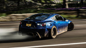 藍色Subaru BRZ在道路上飄移，帶有動態模糊，附近有紫色花朵。
