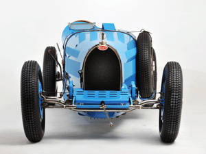 工作室中的復古藍色Bugatti賽車，外露底盤和備用輪胎。