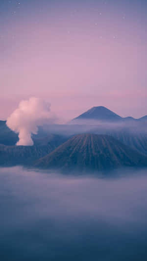 在繁星點點的黃昏天空下，火山峰巒在薄霧中升起。