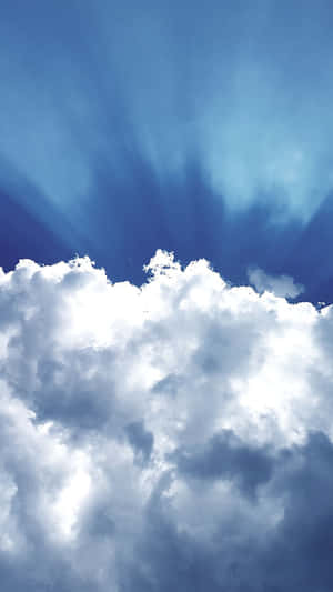 陽光穿過蓬鬆嘅白雲，喺鮮豔嘅藍色天空中閃耀。