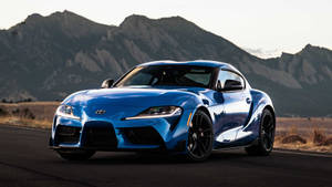 日落時分山路上的藍色跑車