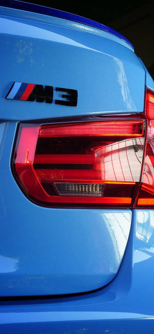 藍色BMW M3尾部徽章及尾燈的近距離特寫。