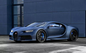啞光藍色Bugatti Chiron停在一棟現代建築前。