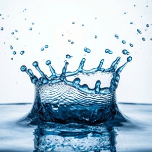 一個皇冠形狀的藍色水花，水滴懸浮在空中。