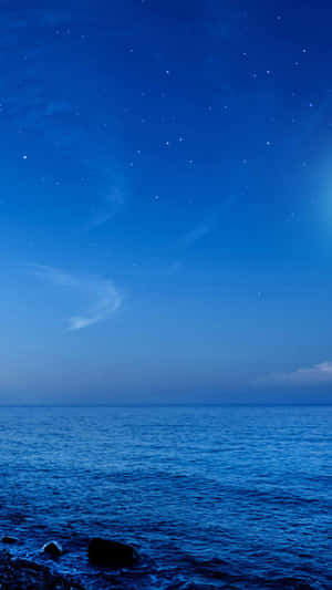 岩石海岸上平靜海洋的星空之夜