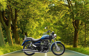 藍色 Royal Enfield 電單車在森林道路上，周圍綠樹成蔭。 — 皇室 壁紙
