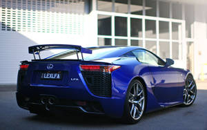 藍色Lexus LFA跑車停在玻璃建築前。