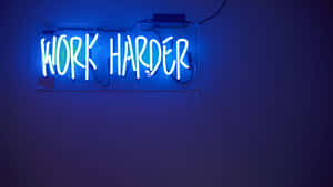 藍色霓虹燈牌，上面有 work harder 文字，安裝在深色牆上。 — 霓虹 壁紙