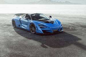 藍色McLaren超級跑車停在沙漠鹽灘上，背景有山脈。 — 4K 法拉利 壁紙