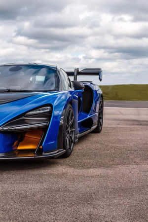 藍色McLaren Senna超級跑車在多雲天空下的瀝青賽道上