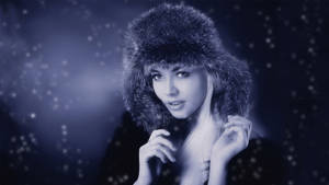 戴皮帽的女性站在飄雪的冬日場景中。