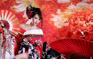 穿著傳統和服的女士手持扇子，背景是秋葉。