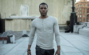 一個穿著灰色亨利衫的男人站在城市屋頂上。 — 拼貼 GIF 壁紙