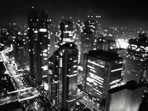 黑白夜景城市景觀，帶有模糊的燈光和高樓大廈。