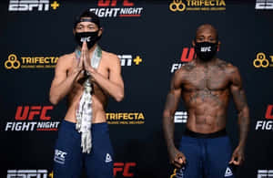 兩名UFC拳手在過磅活動中戴著口罩和藍色短褲。