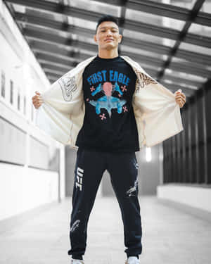 一位男性拳手穿著UFC運動褲和圖案T恤，在現代走廊中拉開外套。