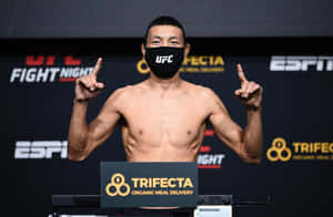 UFC拳手在稱重時戴著口罩並雙食指向上指。