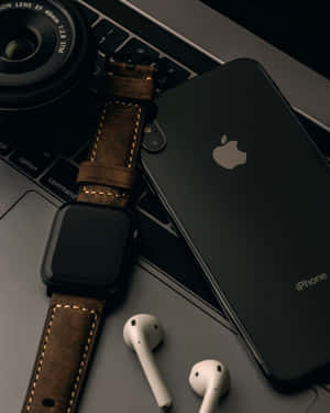 科技產品包括iPhone、手錶、耳機和相機在筆記型電腦鍵盤上。