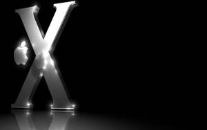 發光金屬X帶Apple標誌，置於黑色背景反射表面