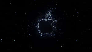 由發光粒子組成的Apple標誌在星空背景中 — 太空 壁紙