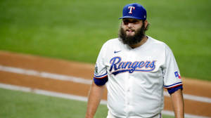 身穿 Rangers 球衣的棒球運動員在球場上行走