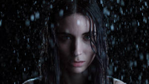 濕髮女人在黑暗環境中透過雨水凝視