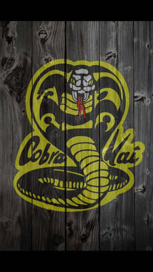 Cobra Kai 標誌以黃色和黑色繪製在深色木質背景上