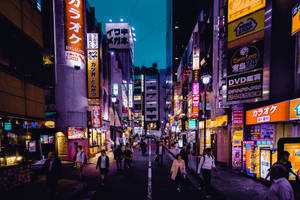 夜晚霓虹燈照亮的東京街道，行人在發光的招牌之間行走。