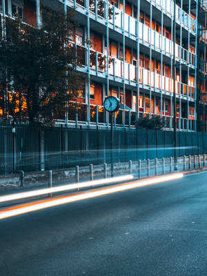 黃昏街道，汽車光軌與亮燈窗戶的建築物。 — 時鐘 壁紙