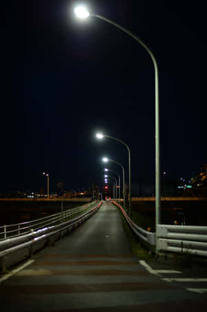 夜晚景色，一條有街燈和遠處城市燈光的照明小徑。