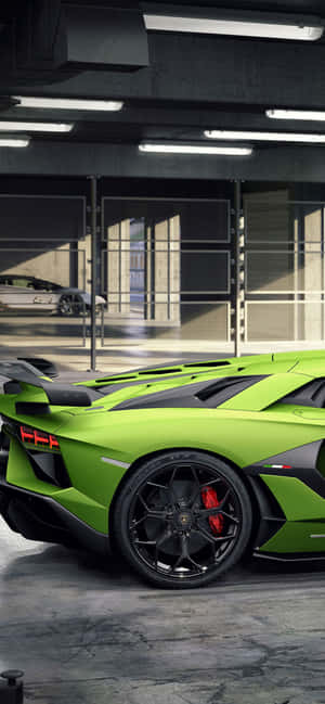 現代工業風車庫中的充滿活力的綠色林寶堅尼 Aventador SVJ。 — iPhone 15 Pro Max 壁紙