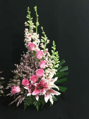 優雅的花束，包含粉紅玫瑰、百合和毛地黃，置於黑色背景上 — iPad Pro 壁紙