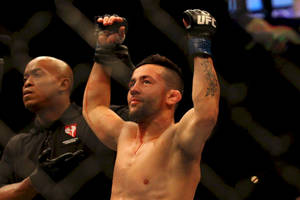 UFC拳手在八角籠內舉起拳頭慶祝勝利。