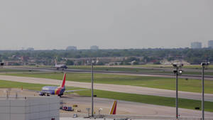 西南航空飛機在機場跑道上滑行，背景為城市天際線。