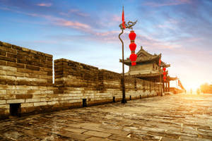 金色夕陽天空下，帶有紅色燈籠的古城牆。 — 中國 壁紙