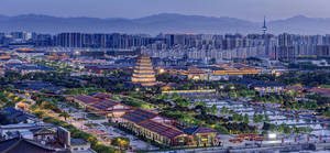 古老寶塔和傳統建築在黃昏時分與現代城市塔樓相映生輝。 — 唐人街 GIF 壁紙