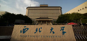 西北大學的石牌，上面有中文字和英文，位於校園建築前。 — 日產 Skyline GTR R33 壁紙