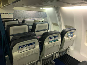 西捷航空飛機機艙，設有乘客座位和安全資訊卡。