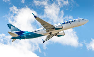 Vestjet飛機在藍天白雲中飛行。